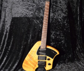 Unique electric guitar on textured black background.