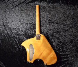 Wooden electric guitar body on dark fabric.