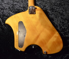 Back of wooden electric guitar on fabric.
