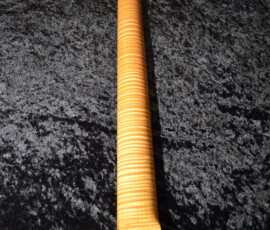 Guitar neck with a striped wood pattern.