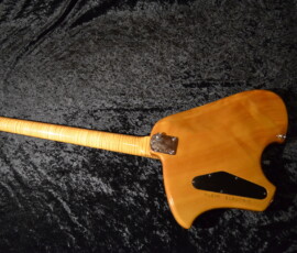 Wooden electric guitar on black velvet background.