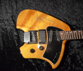 Electric guitar with signature on black background.