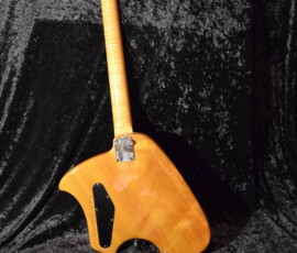 Unique wooden electric guitar on dark fabric.
