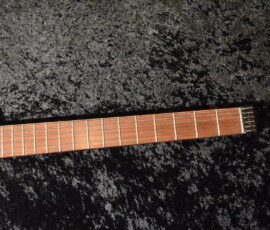 Guitar neck on dark textured background.