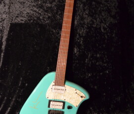 Turquoise electric guitar on dark background.