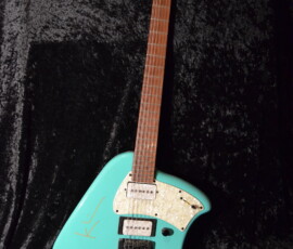 Unique turquoise electric guitar on black background.