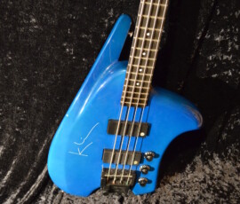Blue electric bass guitar on black background.