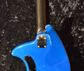 Blue electric guitar back on textured surface.