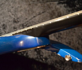 Blue electric guitar neck and body close-up.