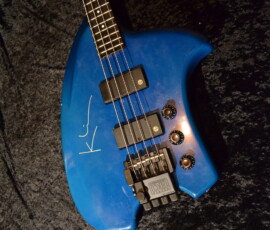 Signed blue bass guitar on black fabric