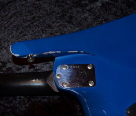 Blue electric guitar with visible paint chips.