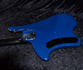 Blue electric guitar on dark textured fabric.