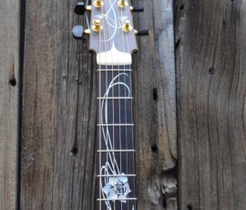 Intricate guitar neck against rustic wooden background.