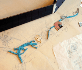Blueprint and scattered decorative elements on table.