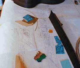 Guitar making materials and plans on table.