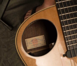 Acoustic guitar with visible label inside.