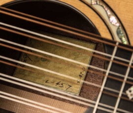 Guitar soundhole with strings and label inside.