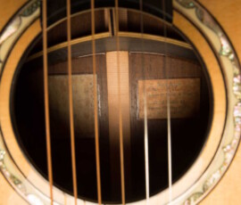 Acoustic guitar soundhole with visible strings.