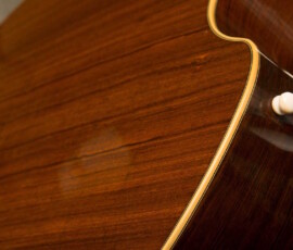Close-up of acoustic guitar's wooden body.