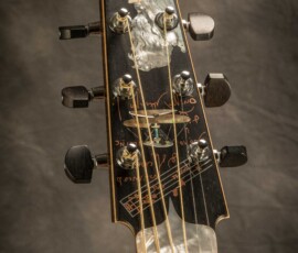 Decorative guitar headstock with intricate design.
