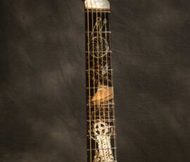 Guitar with intricate inlay designs on neck.