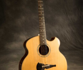 Acoustic guitar against a dark background.