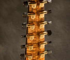 Wooden guitar headstock with tuning pegs.