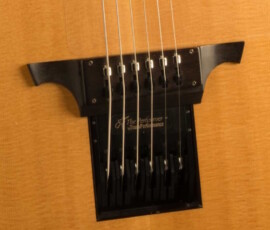 Acoustic guitar bridge with strings close-up.