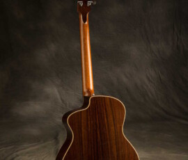 Glossy dark-wood acoustic guitar back view