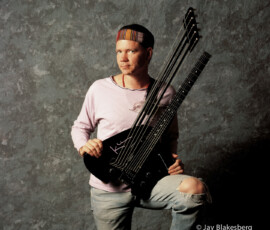 Five-neck electric guitar musician posing