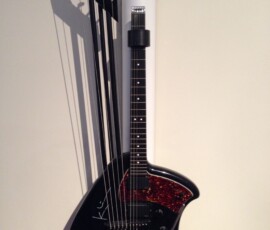 Unique black guitar with extended strings.
