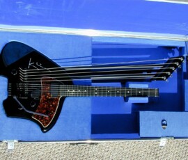 Black multi-neck guitar in blue case.