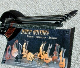 Harp guitar and poster on carpeted floor.
