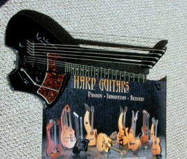 Harp guitar with decorative poster below.