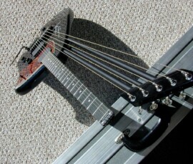 Six-string electric bass guitar on case.
